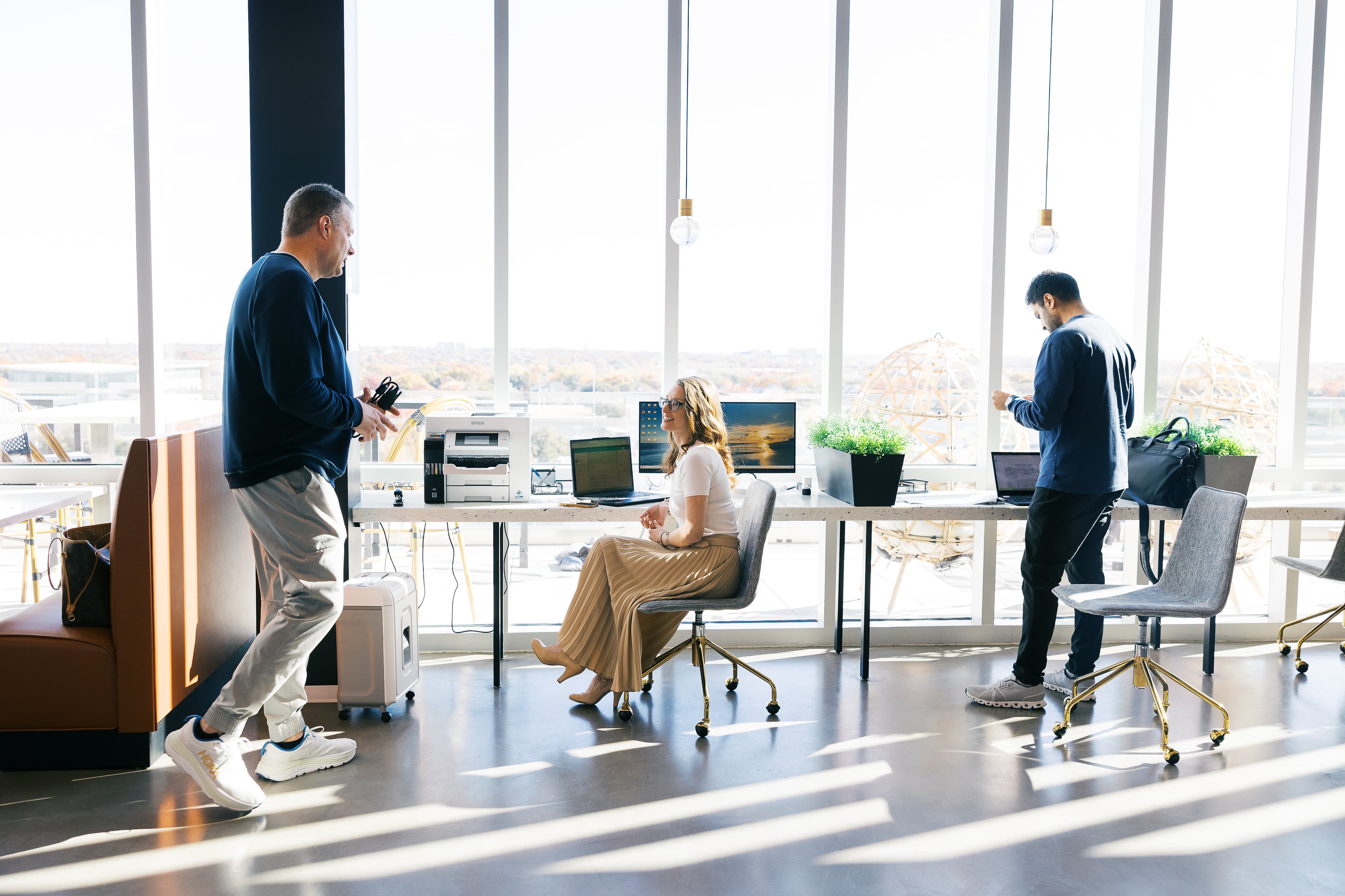 Three people interacting at the Coffee Lounge at Lucid Private Offices at West Plano / Willow Bend